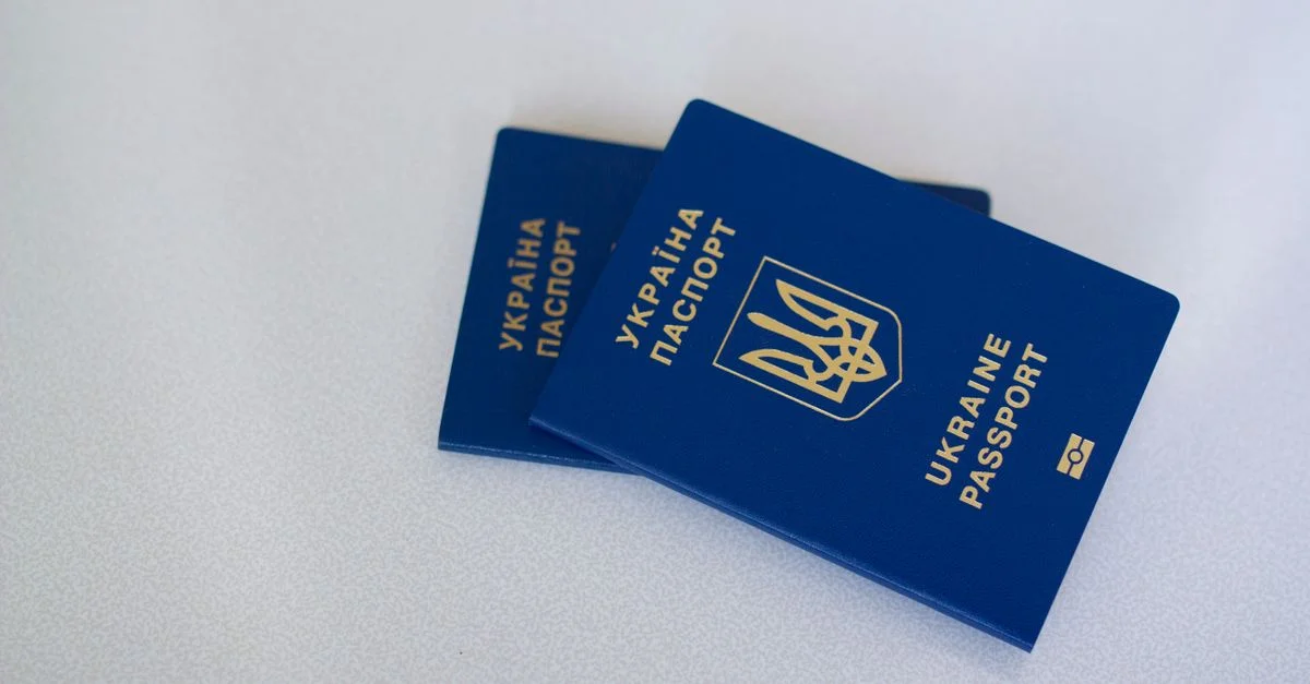 Imagen de dos pasaportes ucranianos sobre una superficie blanca, destacando temas de viaje e identificación.