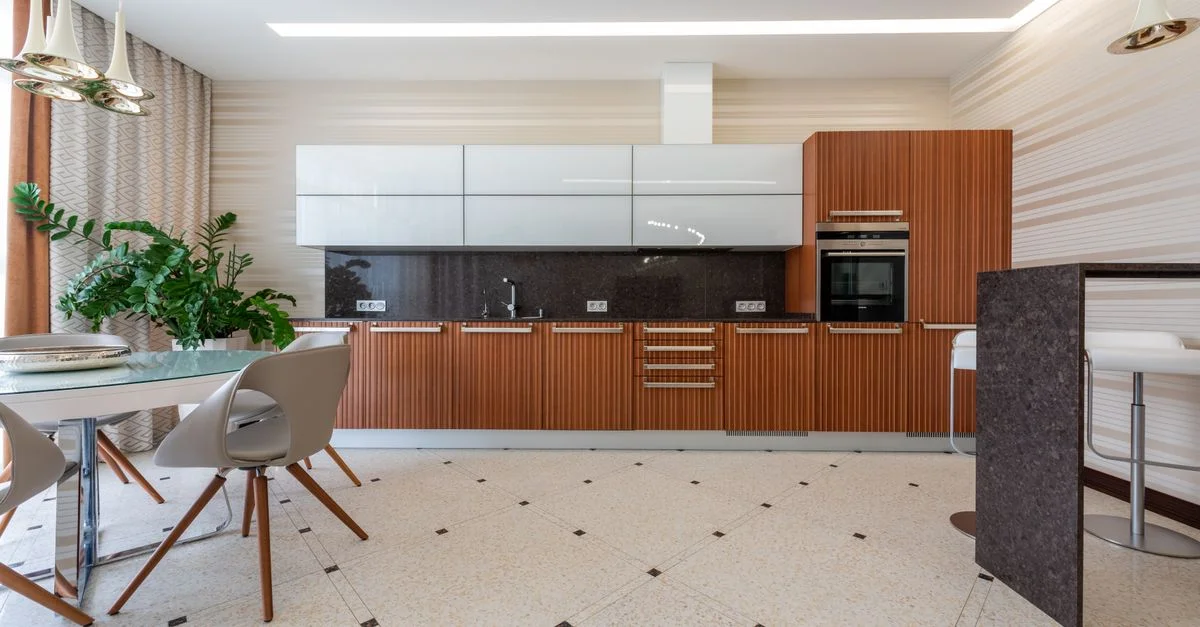 Cocina moderna espaciosa con elegantes armarios de madera, área de comedor abierta y decoración de buen gusto.