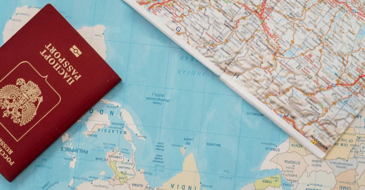 Toma plana de un pasaporte y un mapa, simbolizando aventura de viaje y exploración.