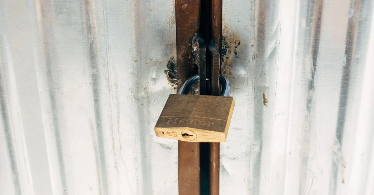 Un candado resistente asegurando una puerta metálica, destacando seguridad y protección.