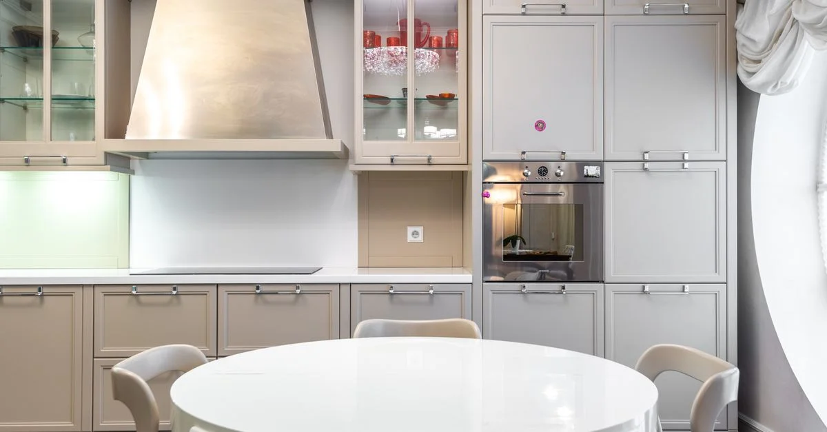 Cocina contemporánea con armarios elegantes y una mesa de comedor redonda.