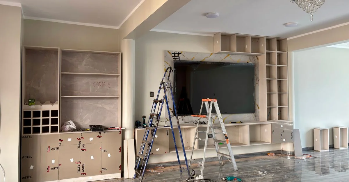 Escena de reforma de interiores con escaleras y herramientas en un salón moderno.